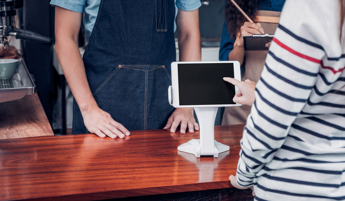 Customer Using A Tablet To Pay For Their Restaurant Bill