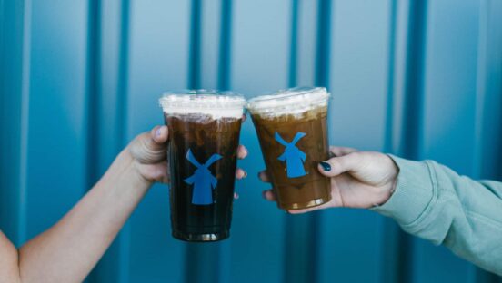 Customers holding Dutch Bros cups.