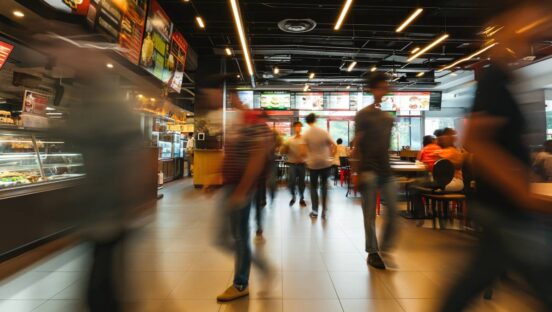 Blurred people walking in fast food restaurant, time-lapse shot.