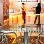 Empty chairs and table next to a fast food restaurant.