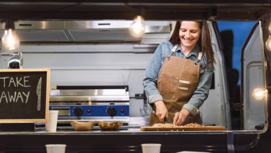 Food truck owner preparing food.