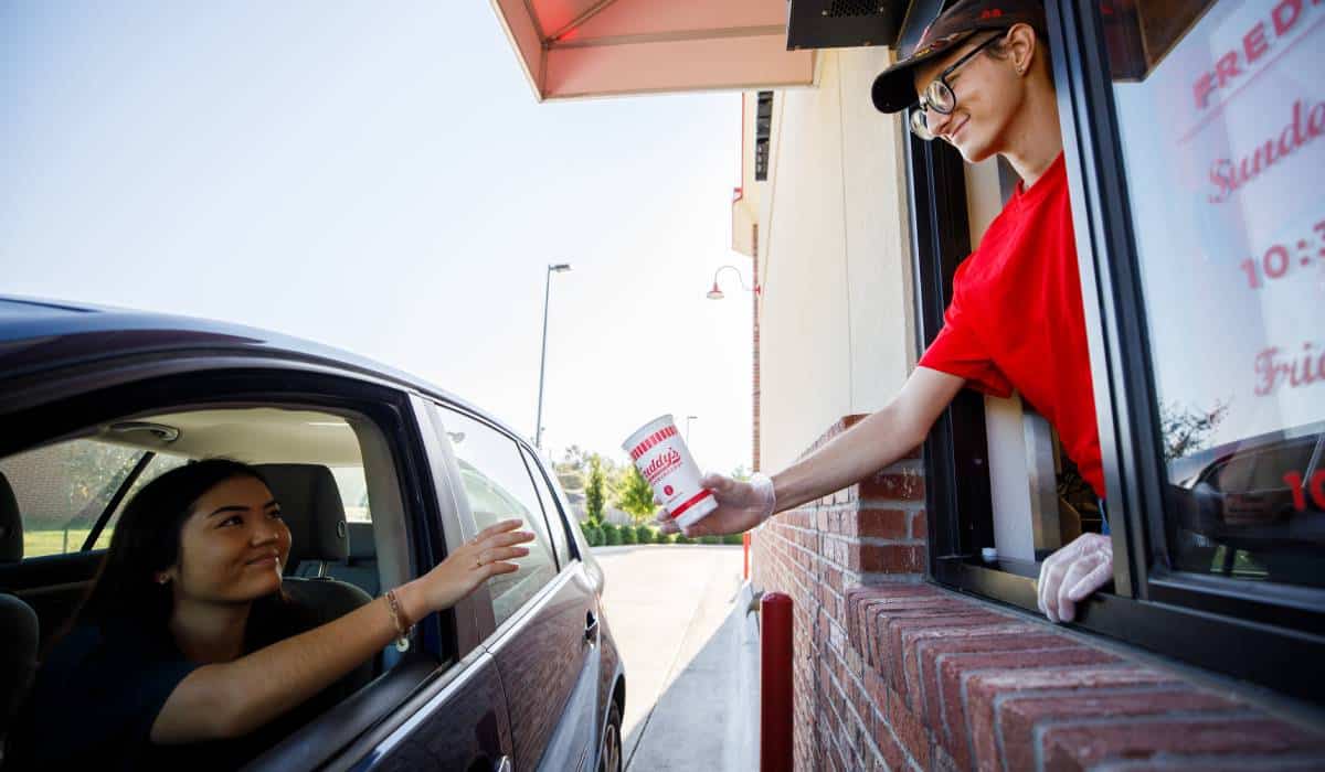 Freddy's Employee Handing A Cup To A Customer