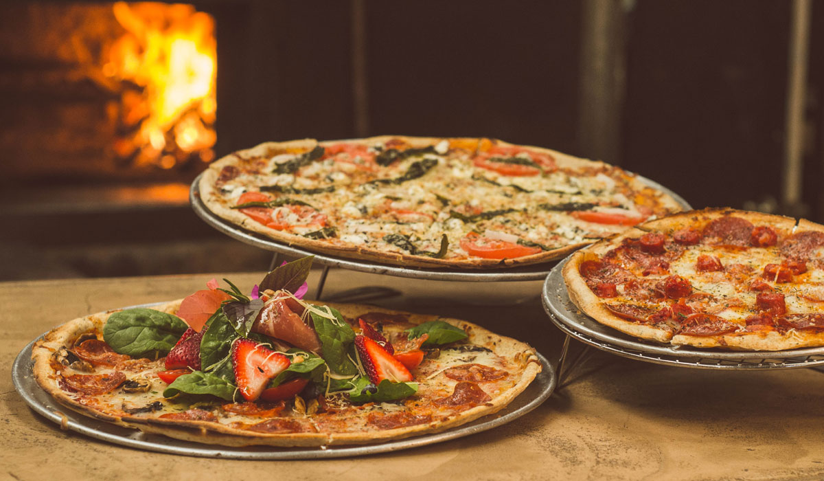 Three Pizzas On Display In A Restaurant