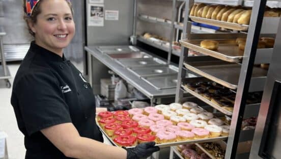 Kaitlyn Venable holding a doughnut tray.