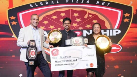 The Bahrain team receiving a check from Pizza Hut.