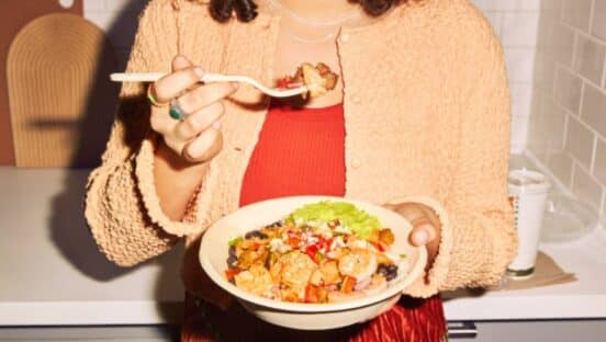 Woman holding a bowl from QDOBA.