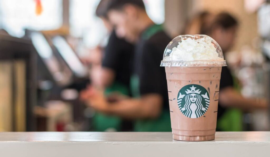 Starbucks' Frappuccino on a table with a blurred background.