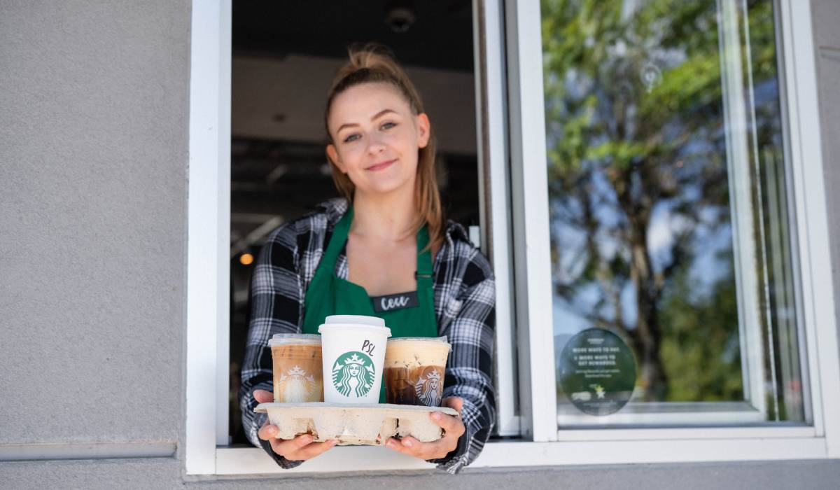 Starbucks Employee Holding Pumpkin Spice Latte