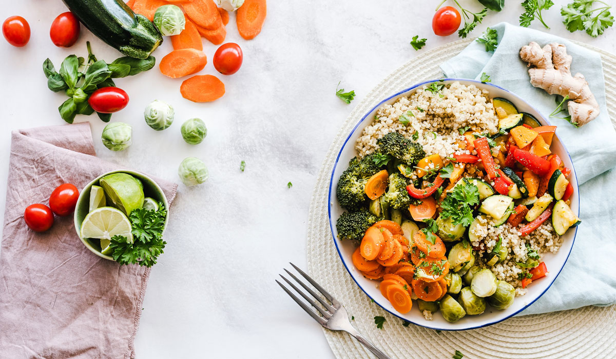 A Bowl Of Healthy Food Next To Vegetables On A Table