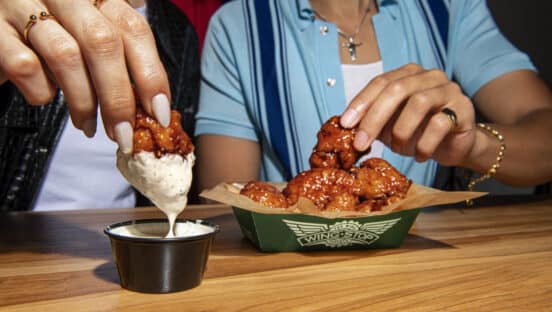 Customers dipping Sweet Chili Glaze wings.