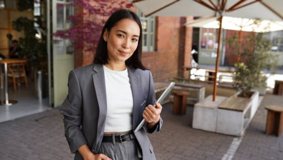 Young elegant professional leader Asian woman, female executive retail manager supervisor, small business owner wearing suit holding digital tablet standing outdoor looking at camera, portrait.